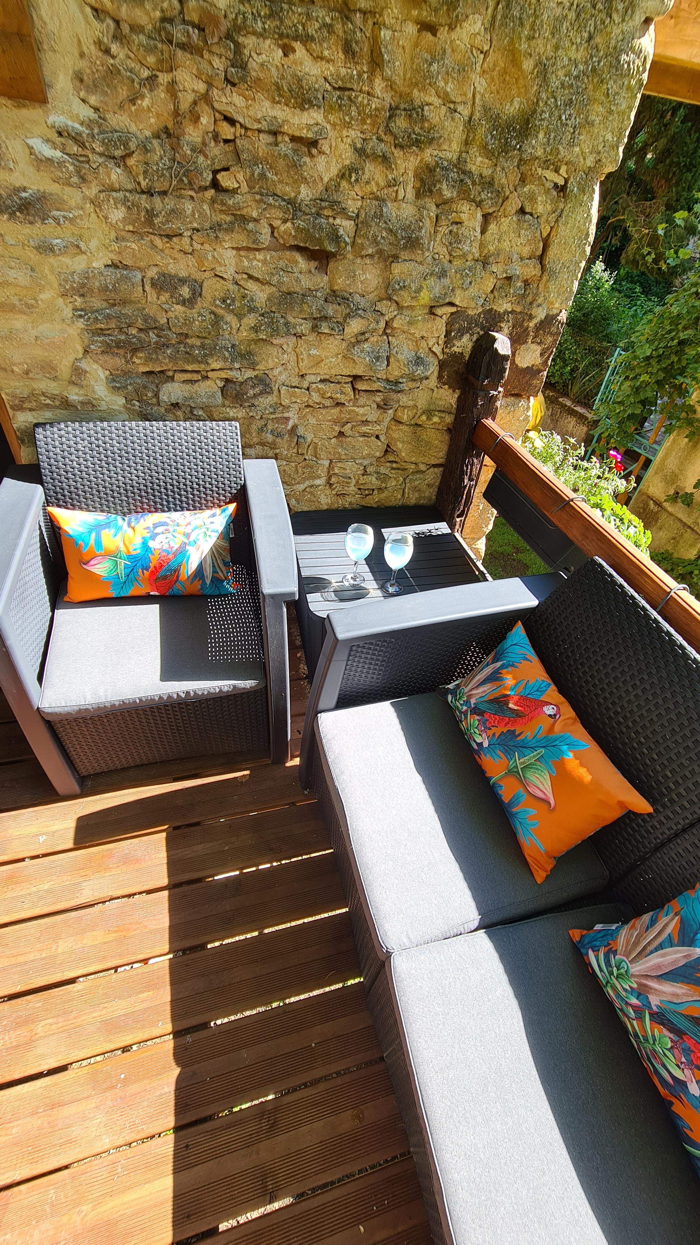 a terrace with space to relax and a table and chairs to eat al fresco overlooking the garden