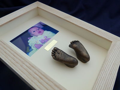 Framed pair of baby feet casts in bronze in oak frame with photo by Rachel Barker Casting