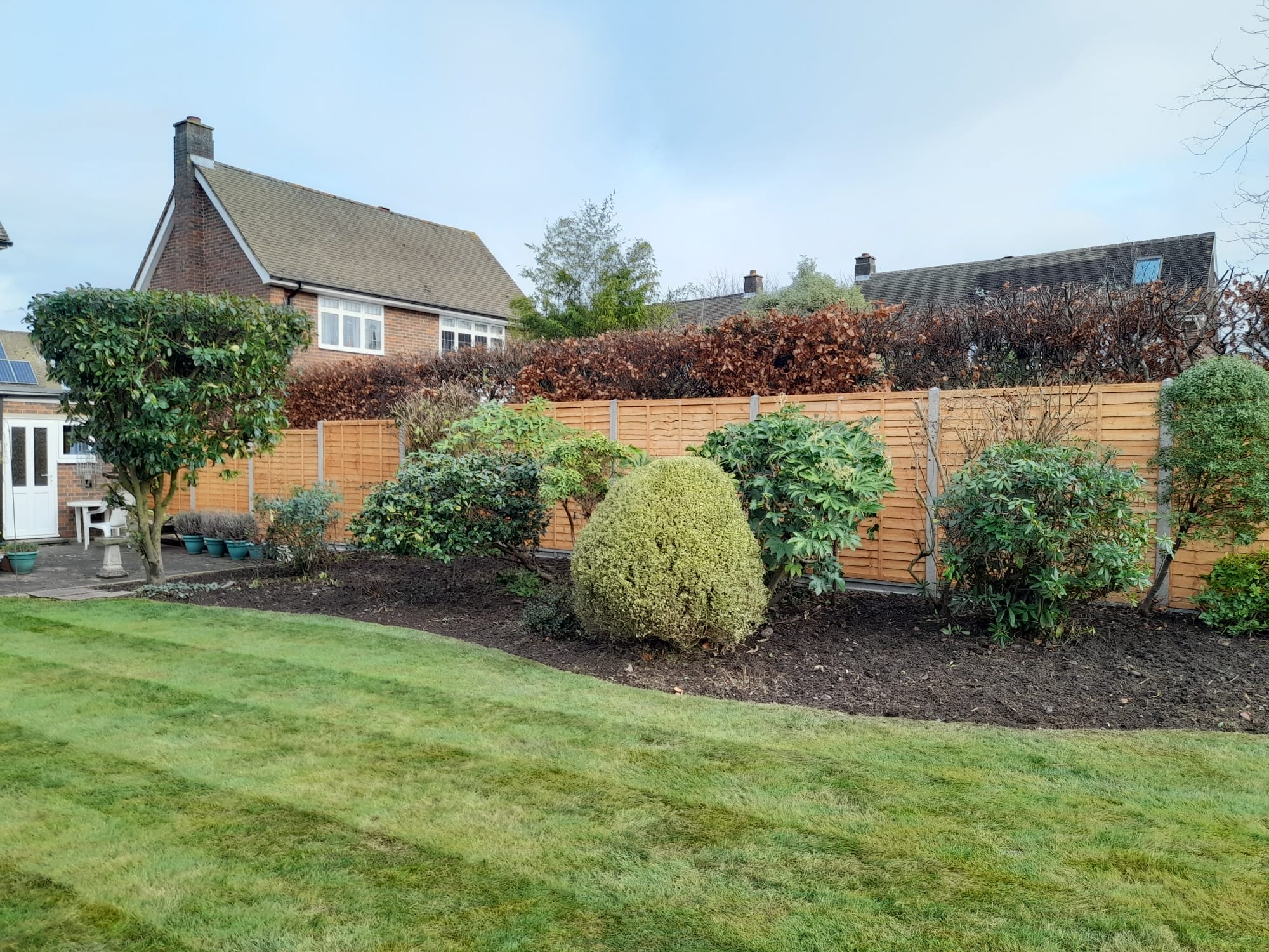 Shrubs neatly pruned, beds weeded and turned over, lawn mowed and edged, new fence erected.