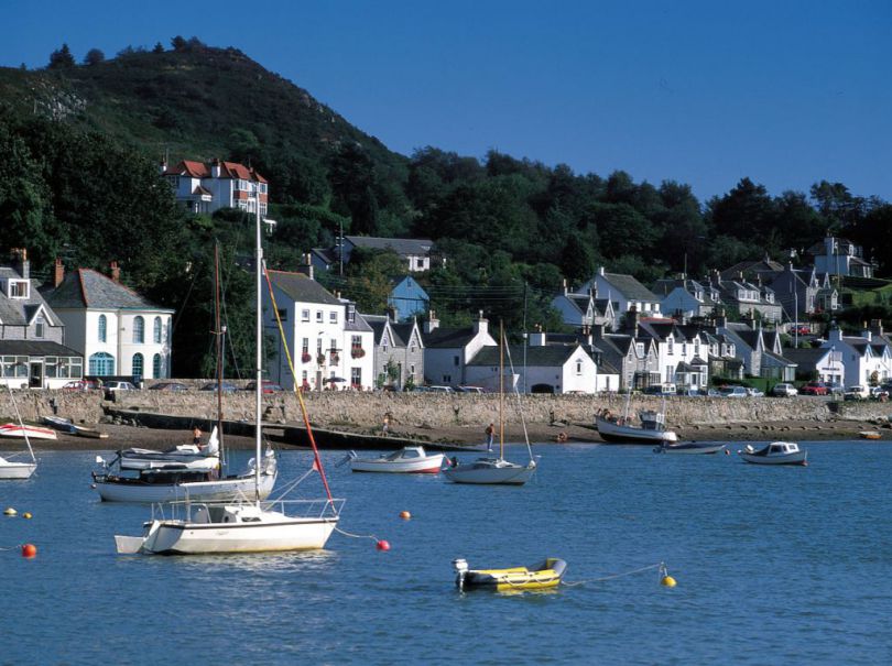 Kippford Marina, south west Scotland, with boats bobbing on the foreshore and houses in the background