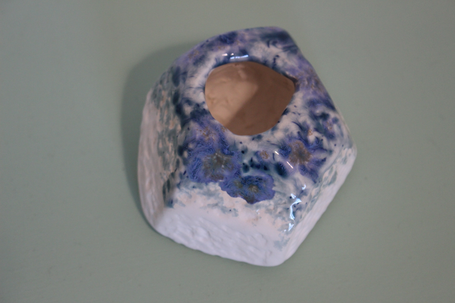 Small porcelain "ink well" pot with blue glaze on top edge