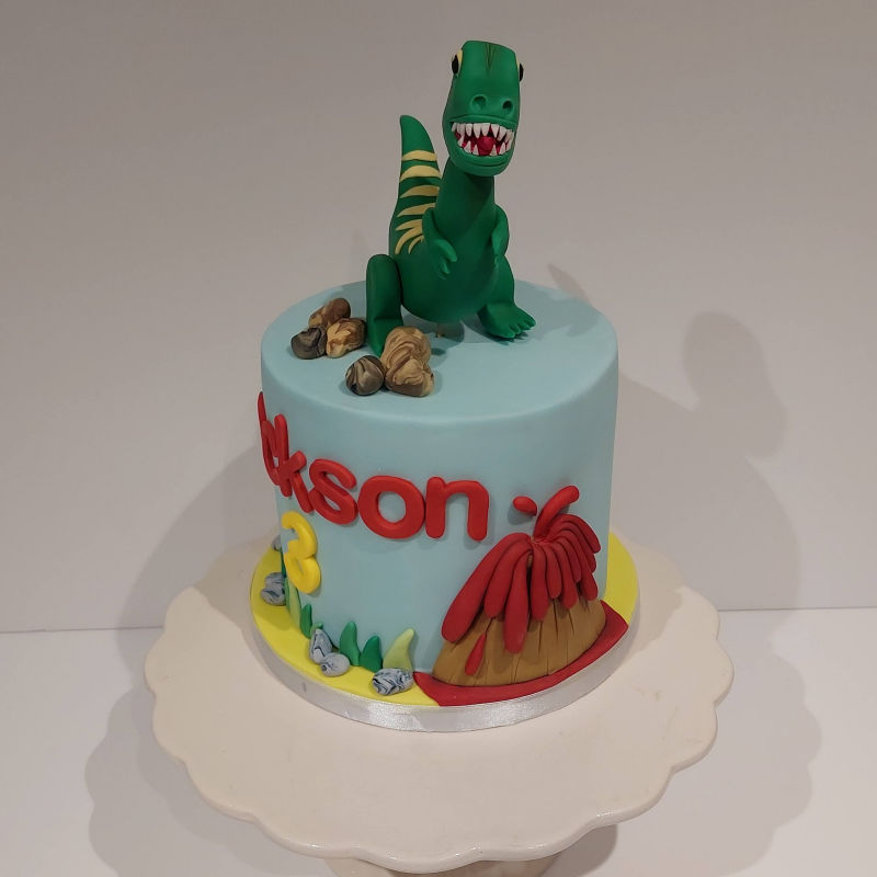 A dinosaur themed cake with a volcano.