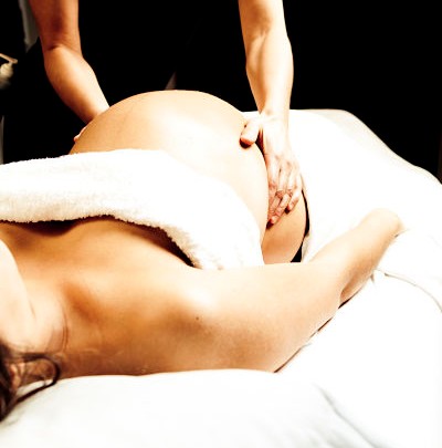 Woman receiving pregnancy massage on treatment couch
