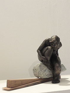 Fired clay figure on stone and wood
