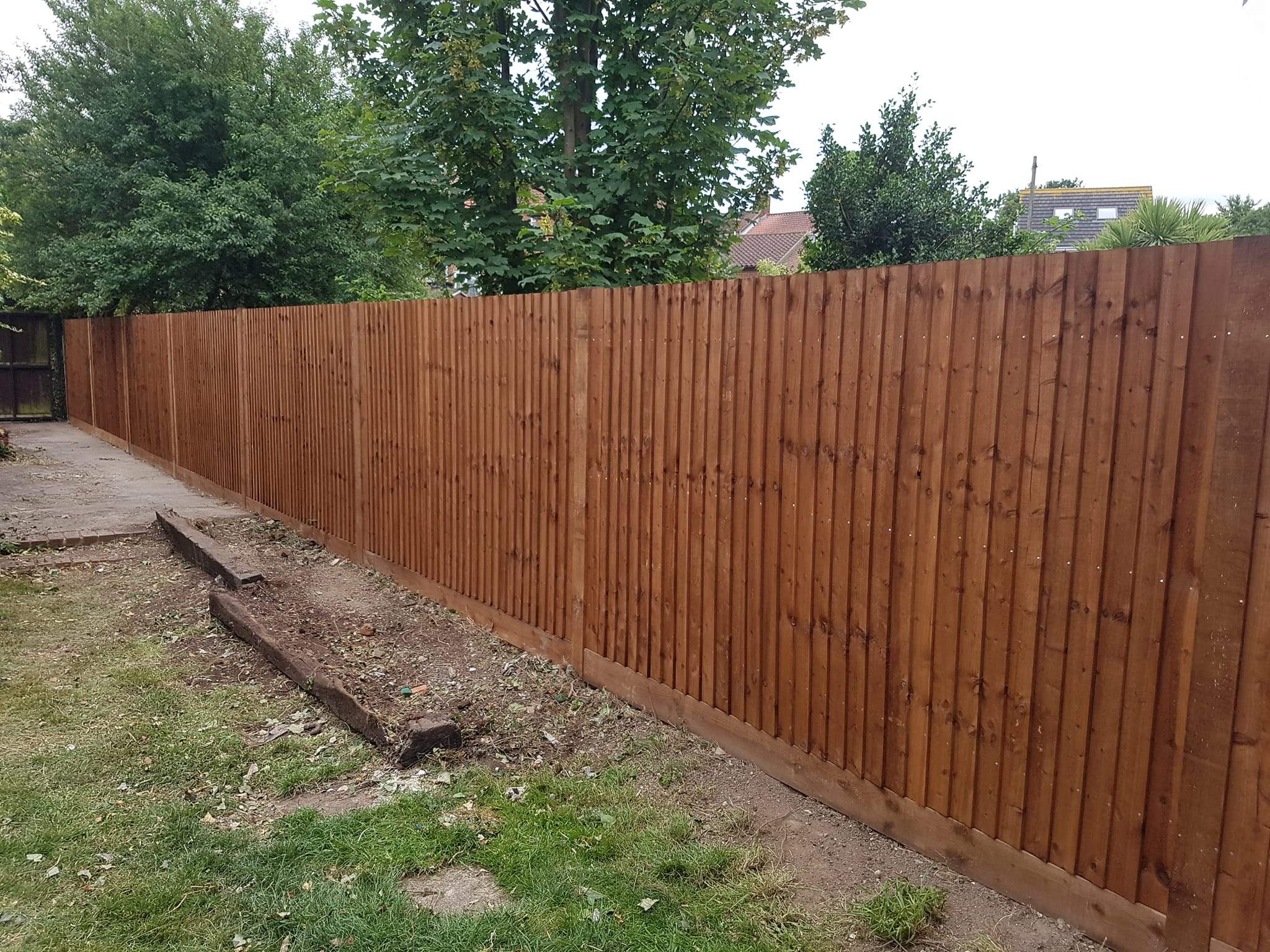 With wooden posts and gravel-boards,fencing installed  in Rochester