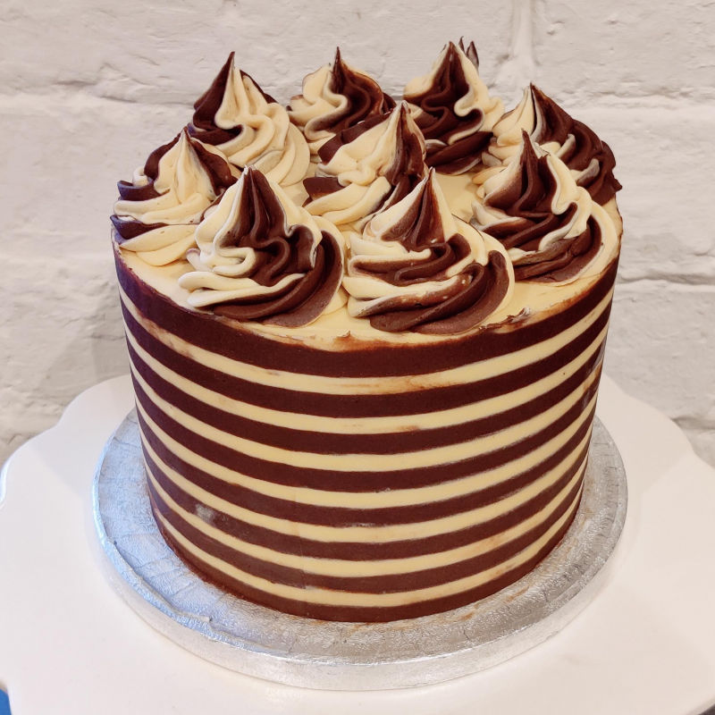 A buttercream decorated cake with horizontal stripes.