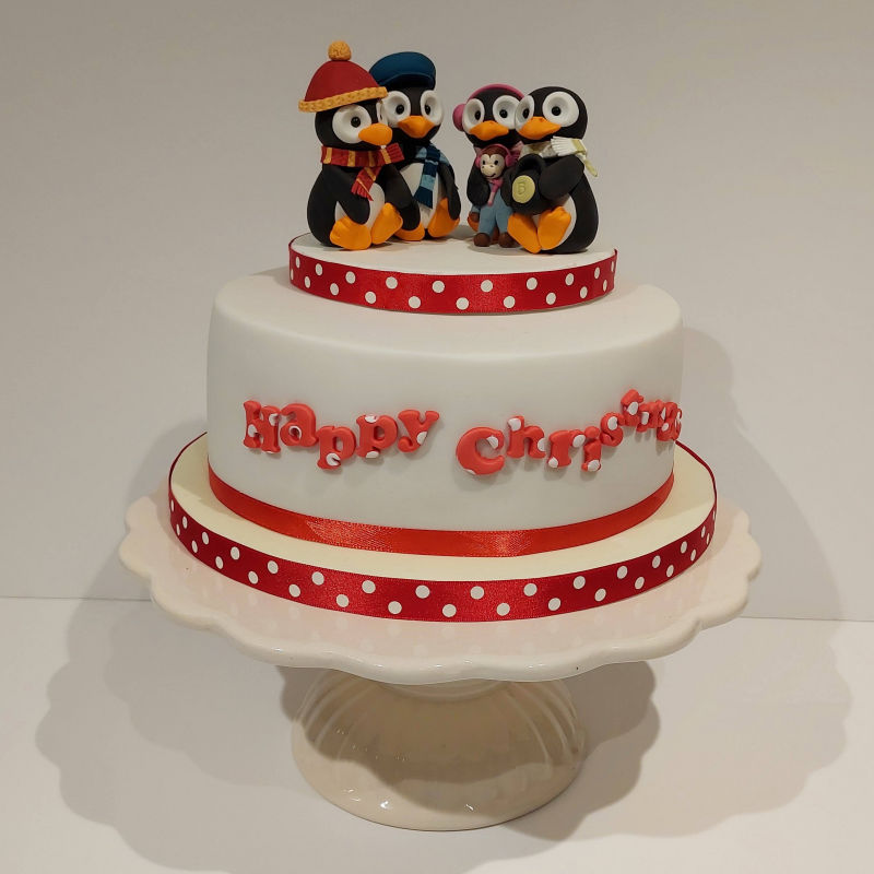 A penguin themed Christmas cake.