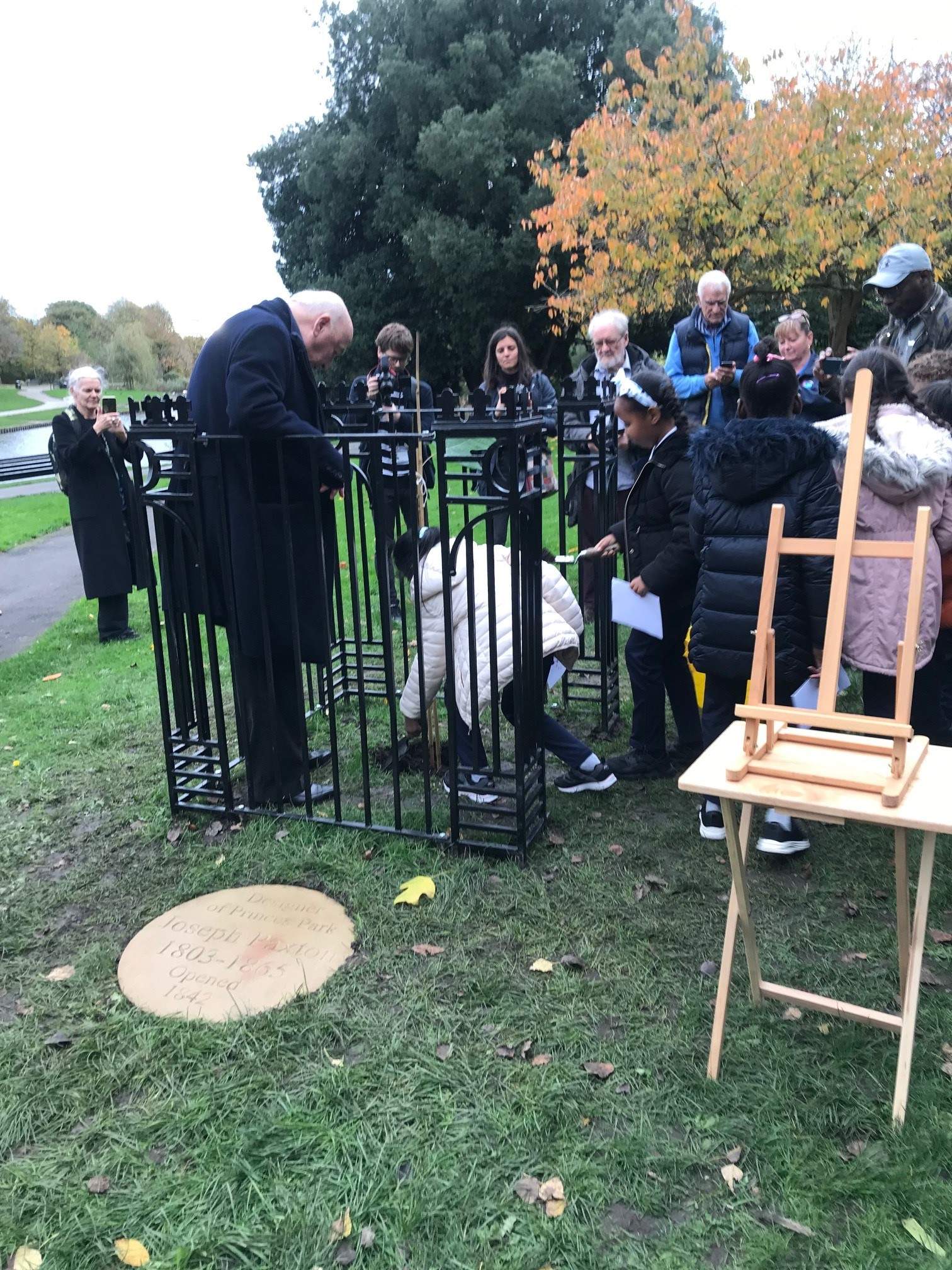 Children help plant the tree under the watchful eye of the Duke