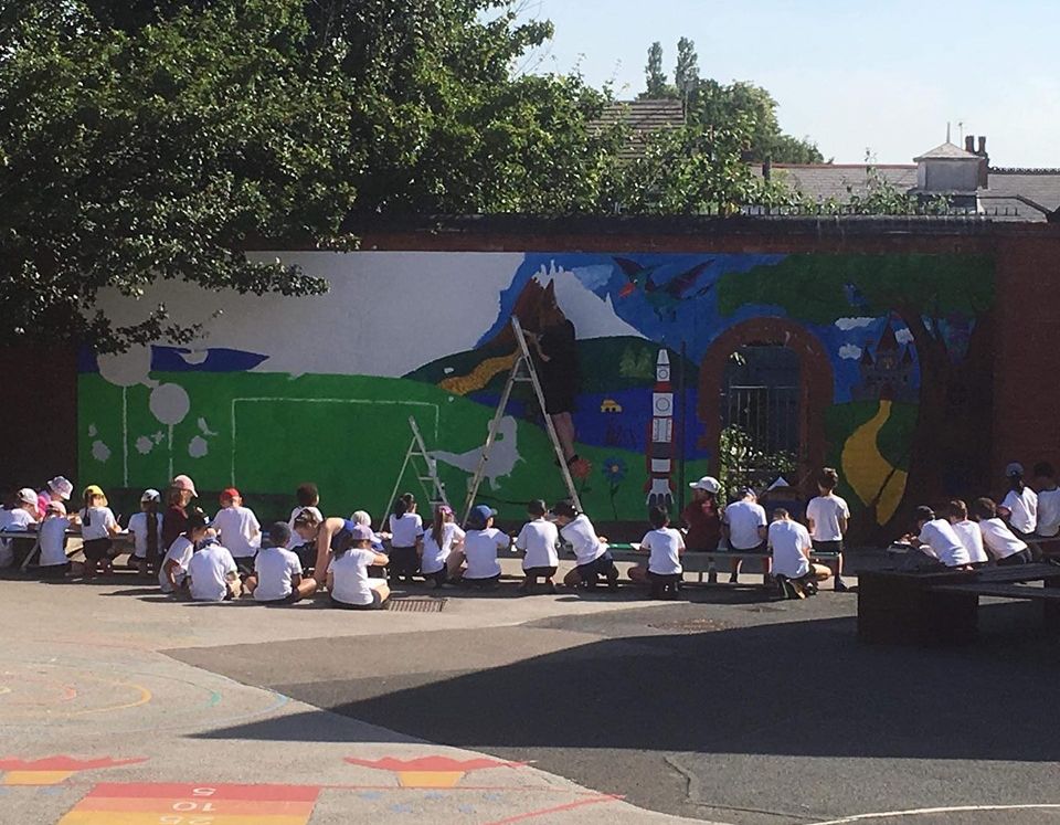 The students watching the mural being painted at Harborne Primary School