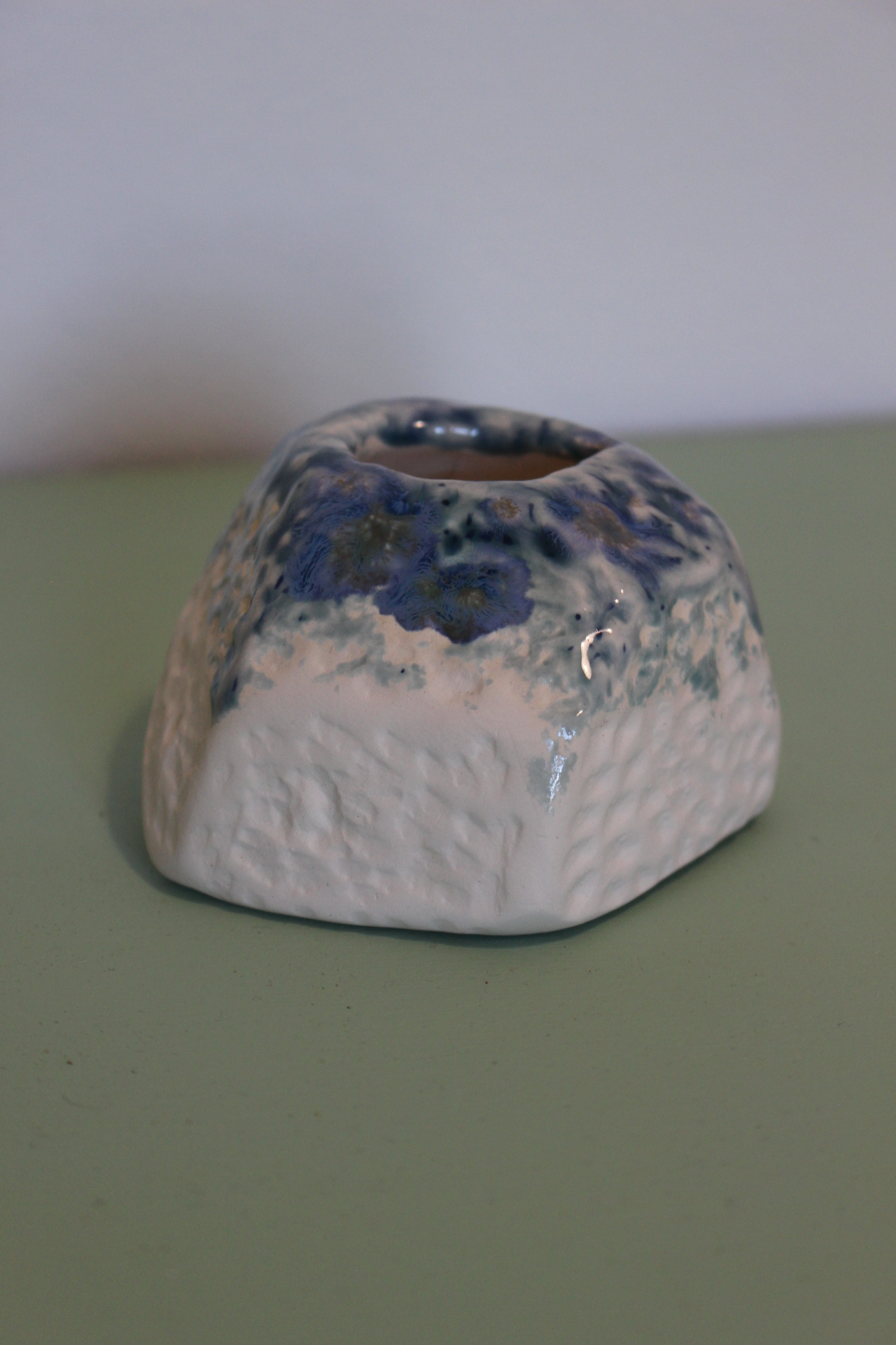 Small porcelain "ink well" pot with blue glaze on top edge