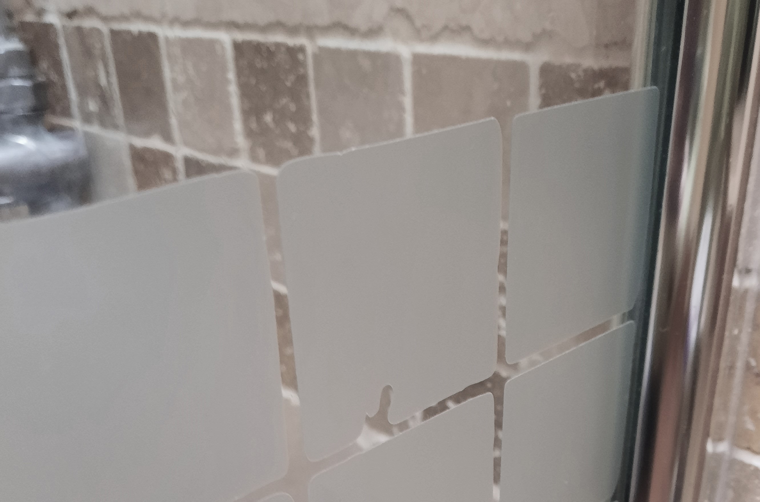 Frosting designed to match the bathroom tiles and provide visibility of the glass divide.
