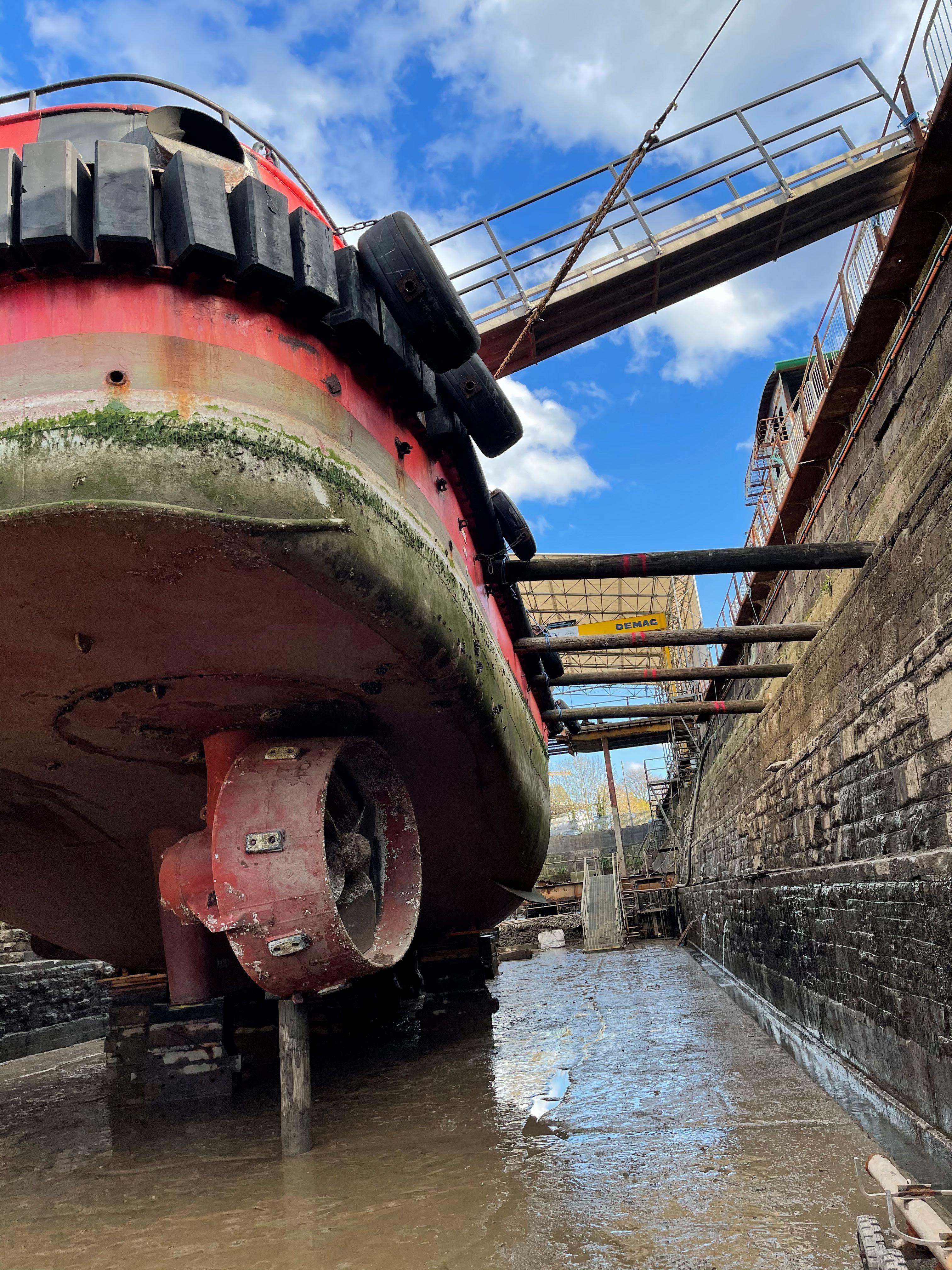 red boat against blue sky in dry dock