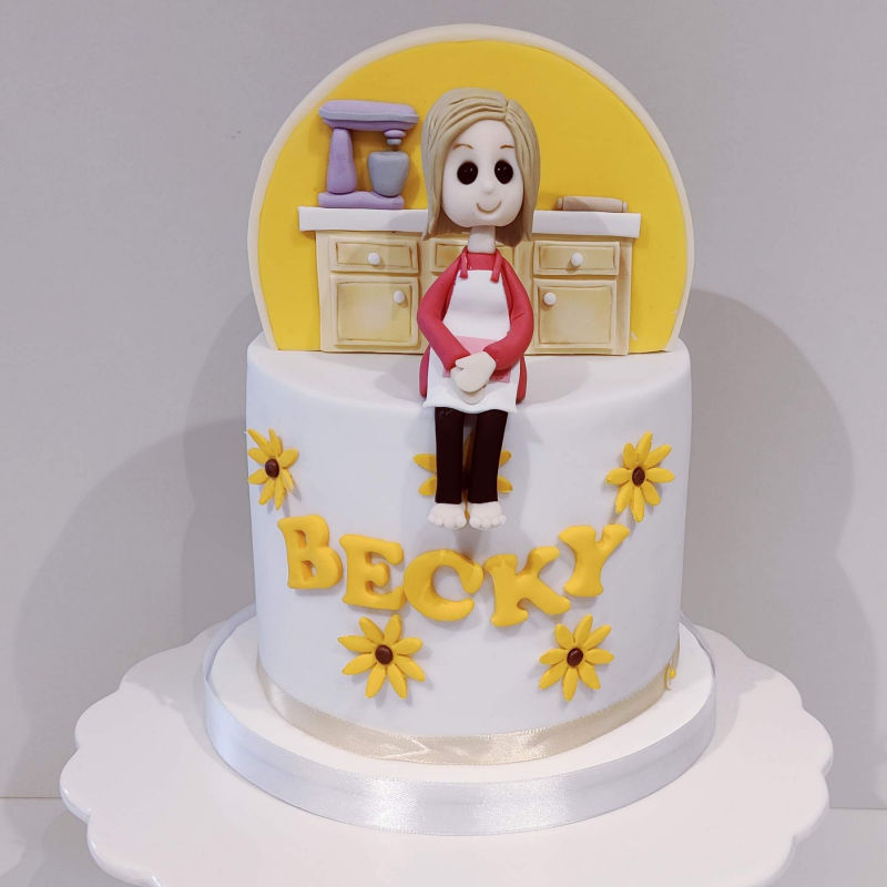 A baker themed cake with character topper.