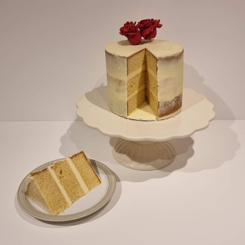 Plain naked cake with slice removed.