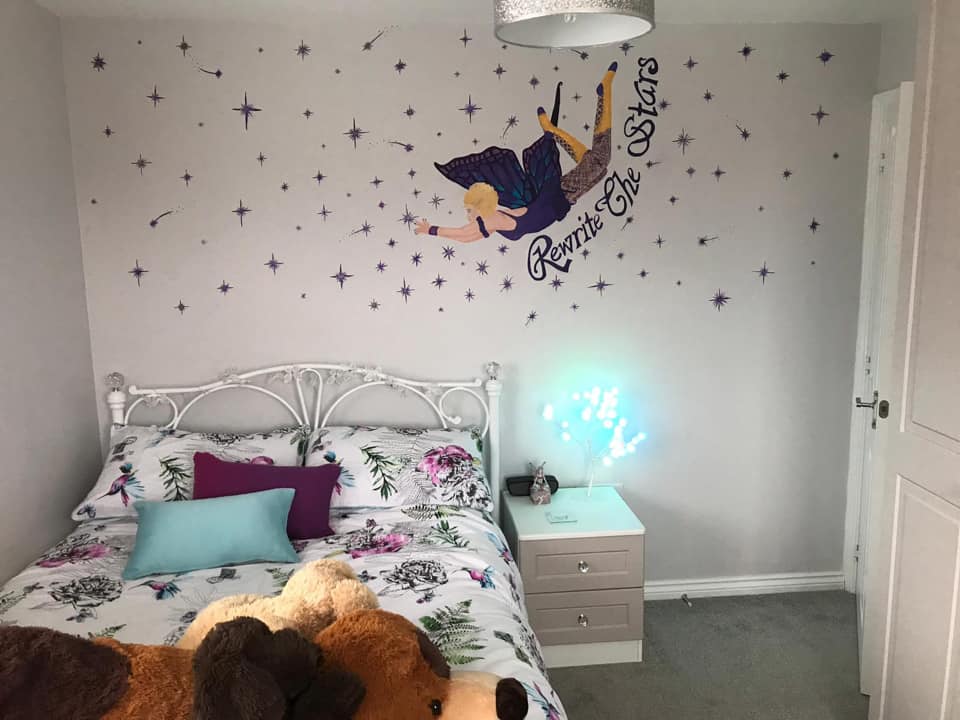 Using glitter paint to create sparkly stars for bedroom mural