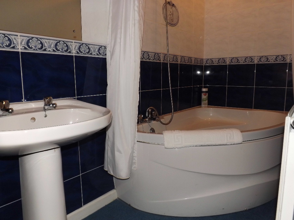 Portpatrick self catering holidays - A bathroom with corner bath at Braefield House, Portpatrick