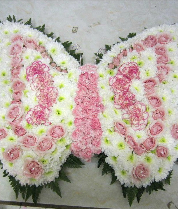 A funeral wreath from Flowers for You, Dalbeattie, using pink roses and white chrysanthemums in the shape of a beautiful butterfly