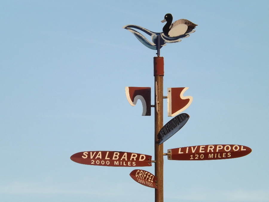 A finger post sign with distances to Svalbard, Liverpool and the Criffel at Carsethorn in Dumfries and Galloway, Scotland Kirkbean.org