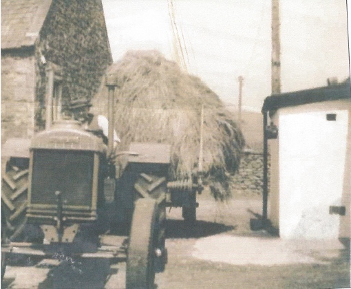 tractor with haystack in a farmyard