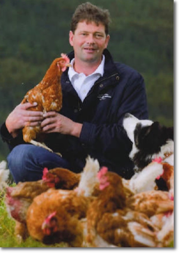 Owner Bruce McMyn surrounded by his Lohmann hens and a collie dog
