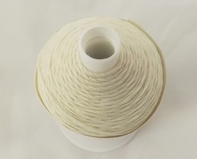 natural shade of linen slipping thread on a bobbin